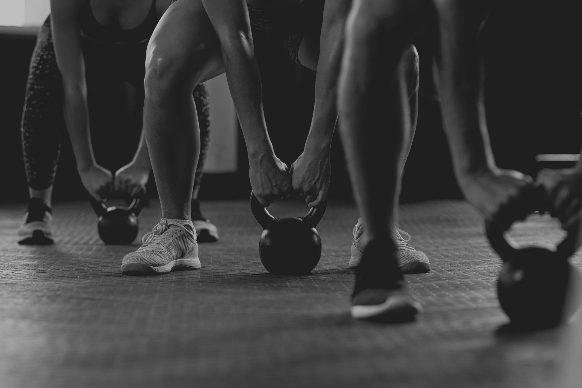 People Lifting Kettle Bells at the Gym